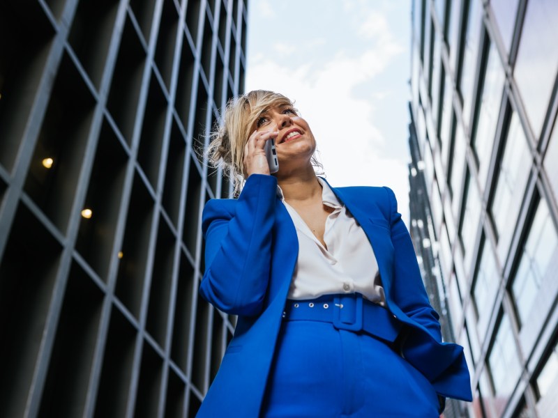 Geschäftsfrau telefoniert auf dem Weg ins Büro im Finanzviertel.