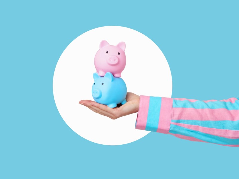 Zwei Sparschweinen balancieren auf einer Hand.