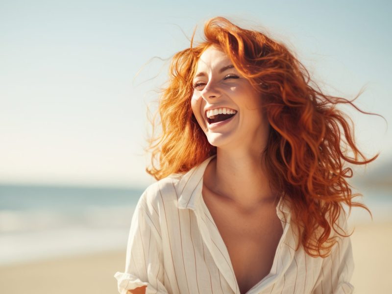 Frau am Strand mit roten Haaren