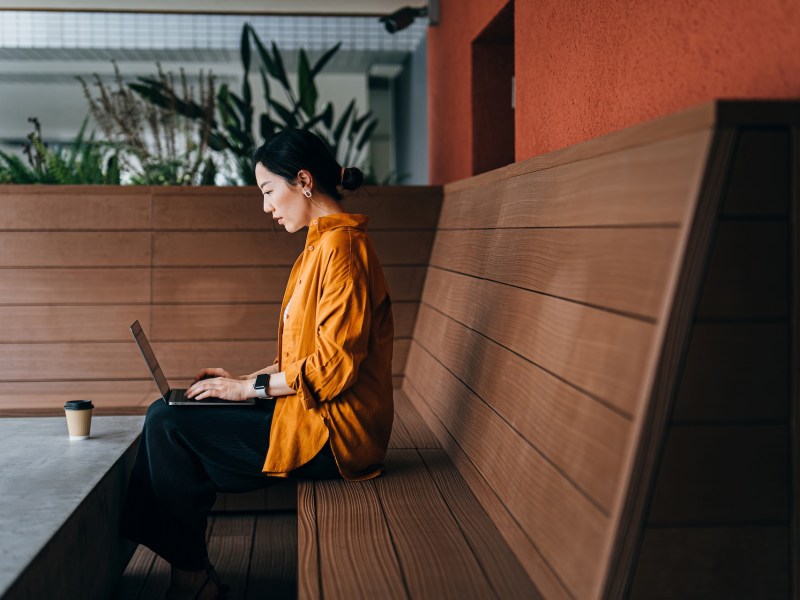 Junge Frau sitzt vor ihrem Laptop.