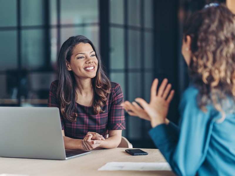 Zwei Frauen führen in einem Meetingraum ein Gespräch.