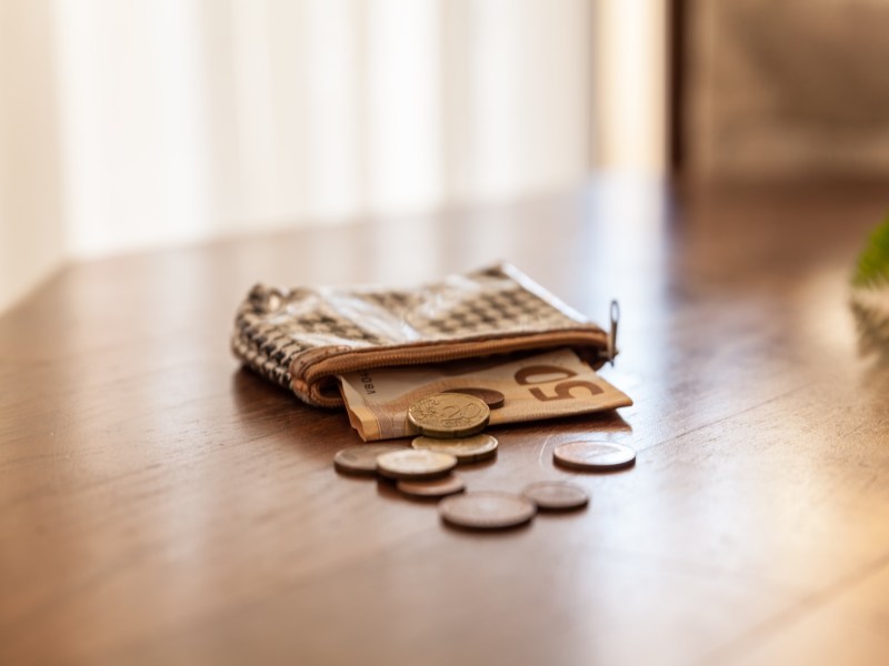 Geldbörse mit Geld auf dem Tisch.