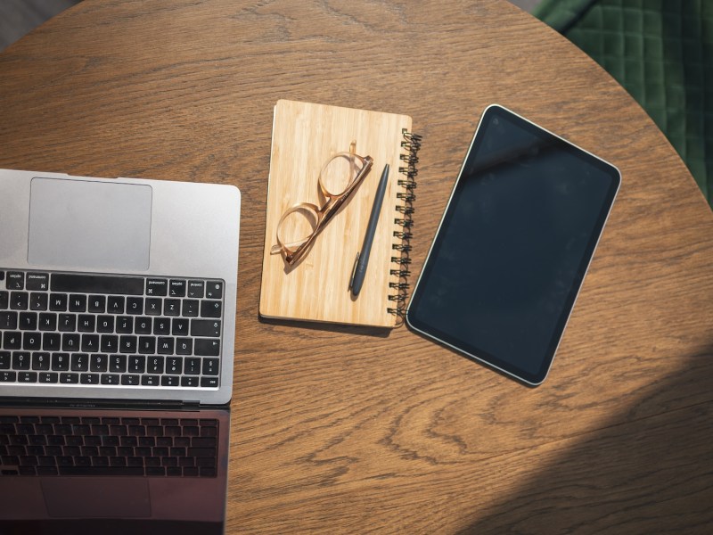 Übersicht über ein Tablet mit leerem Bildschirm und einen Laptop auf einem Schreibtisch.