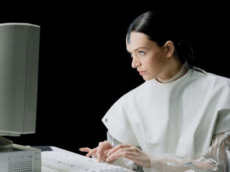 Futuristische Frau sitzt am Laptop.