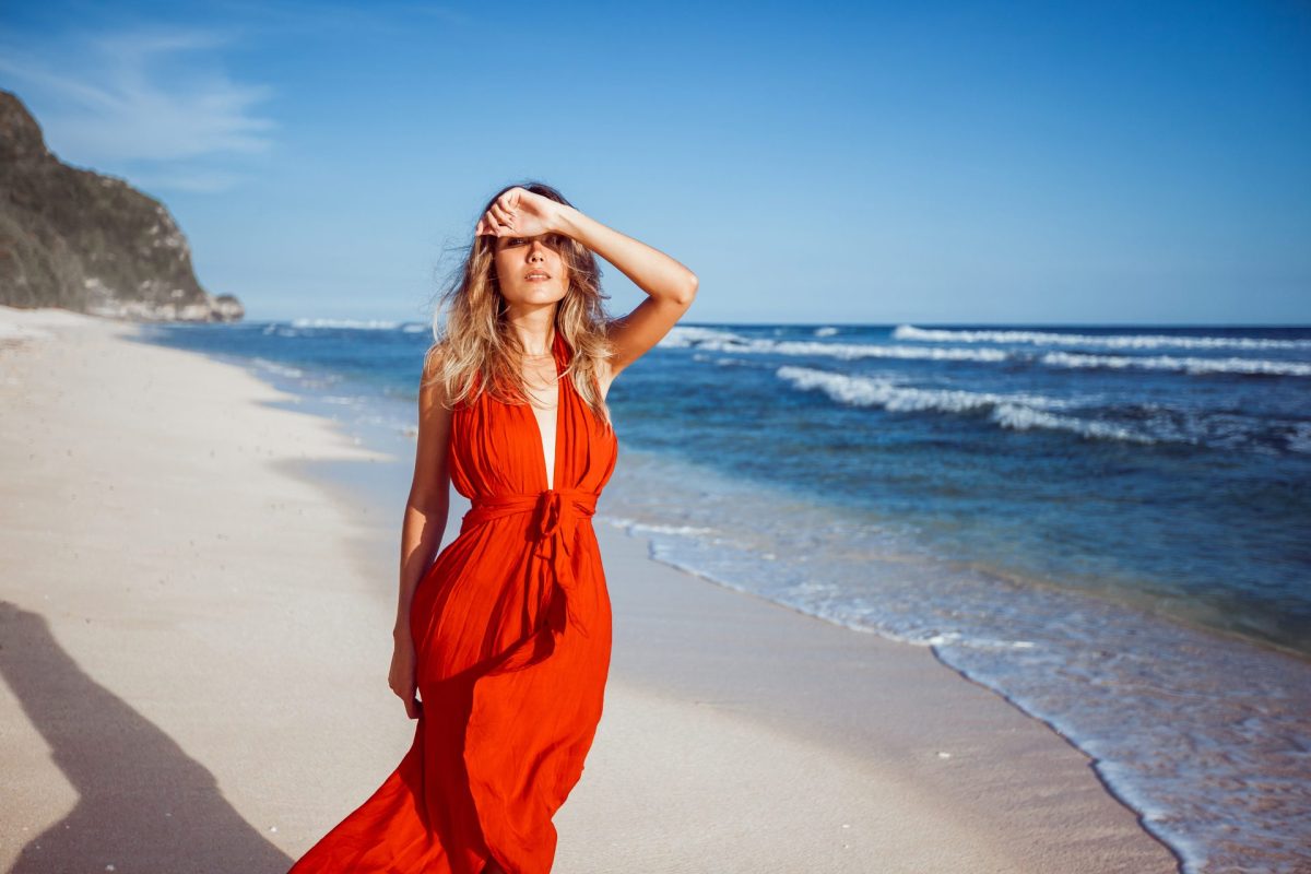 Frau mit rotem Kleid am Strand