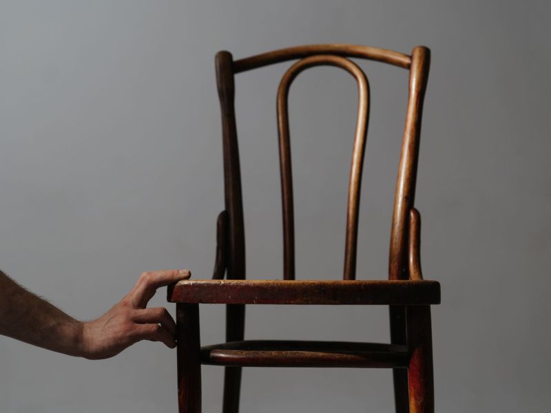 Hand berührt einen Holzstuhl