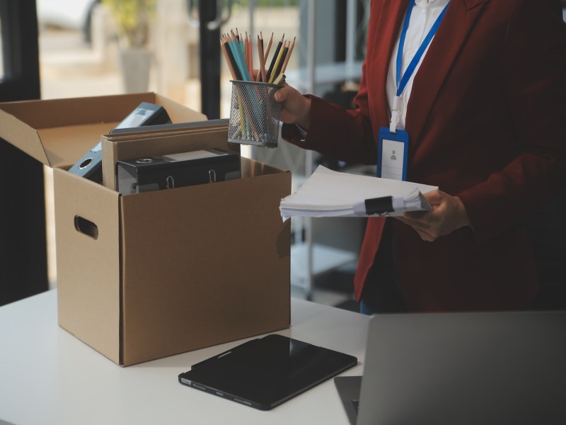 Geschäftsfrau packt ihre Sachen in einen Karton.