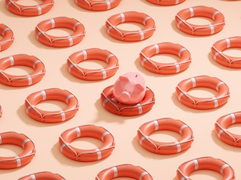 Konzeptbild eines einzelnen Sparschweins in einem Rettungsring.
