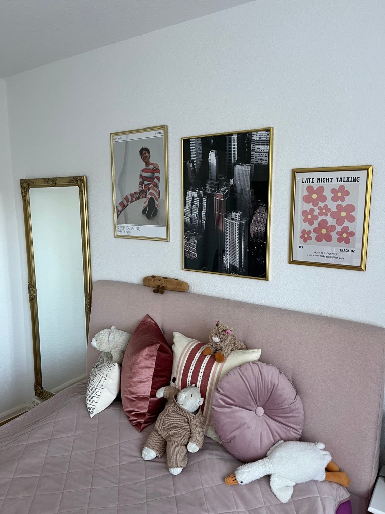 3 Poster in einem Schlafzimmer über dem Bett.