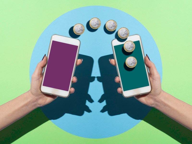 Zwei Smartphones in den Händen von Frauen beim Geldüberweisen.