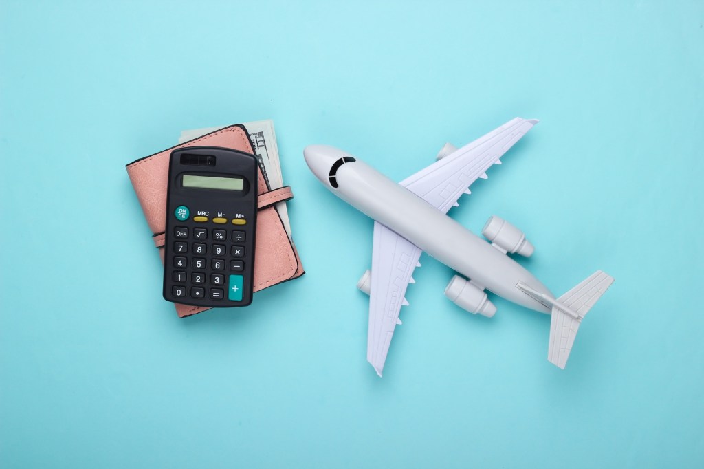 Flugzeugspielzeug, Geldb&ouml;rse, Taschenrechner auf blauem Hintergrund. 