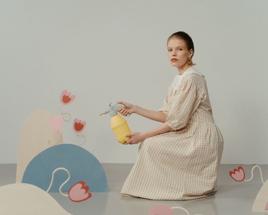 Frau gie&szlig;t Plastik-Blumen