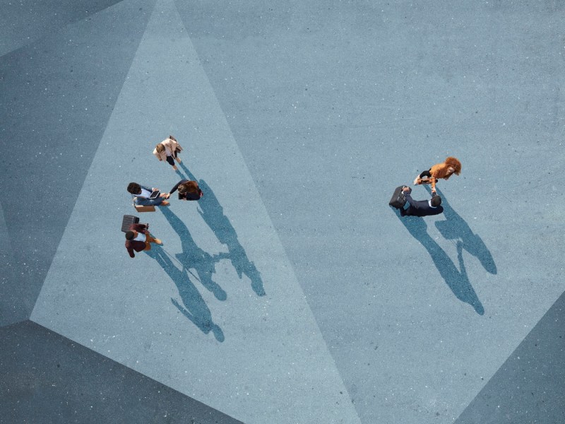 Gruppe junger Erwachsener, von oben fotografiert, auf unterschiedlich bemalten Asphaltoberflächen.