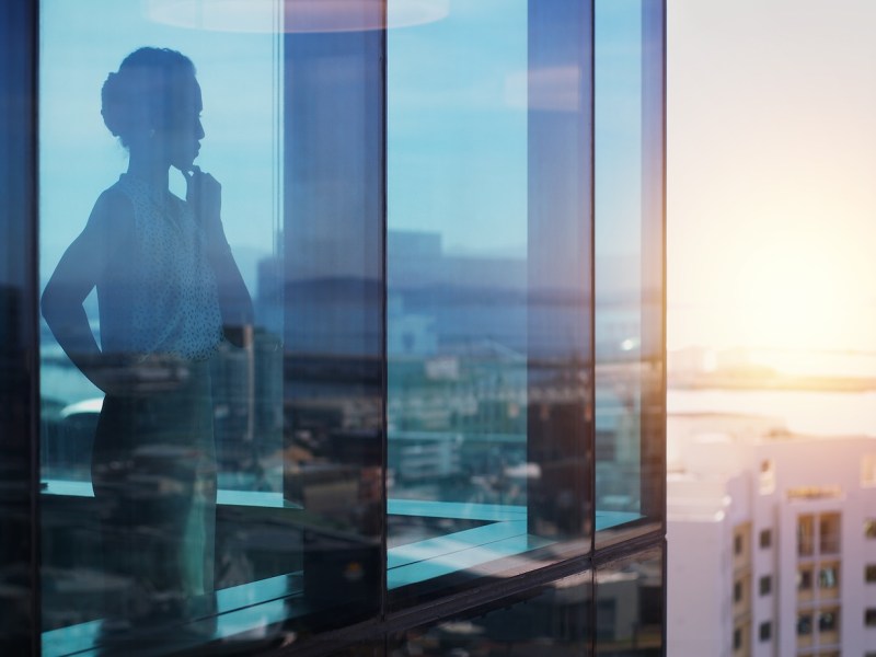 Aufnahme einer Geschäftsfrau, die nachdenklich aussieht, während sie aus dem Fenster schaut.