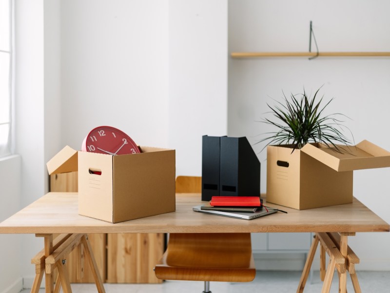 Leerer Büroraum mit Möbeln und Umzugskartons.