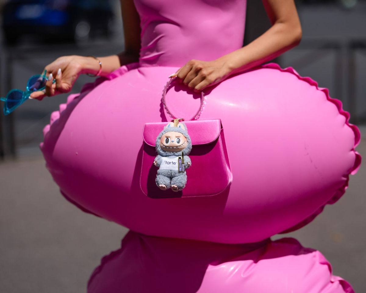 Frau in Pink trägt einen labubu an ihrer Tasche