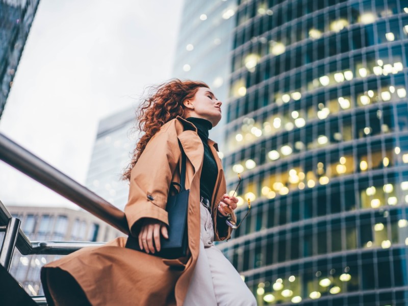 Gestresste Geschäftsfrau vor einem Bürogebäude.