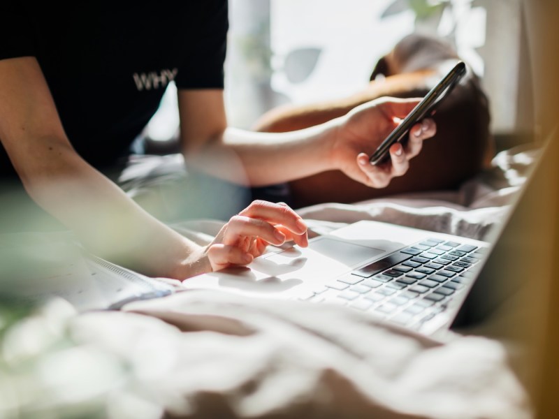 Eine junge Frau sucht eine Nummer im Internet raus.