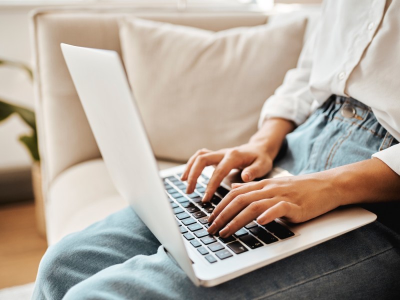 Eine Frau arbeitet am Laptop. Man sieht nur ihre Hände.