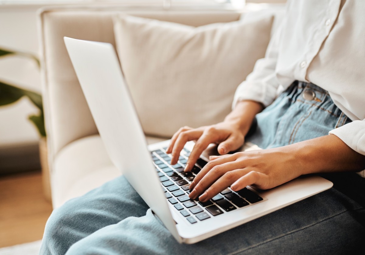 Eine Frau arbeitet am Laptop. Man sieht nur ihre Hände.