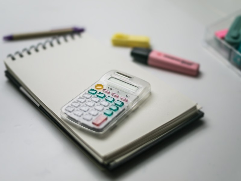 weißer Taschenrechner und Bleistift und einige Clips in Weiß.