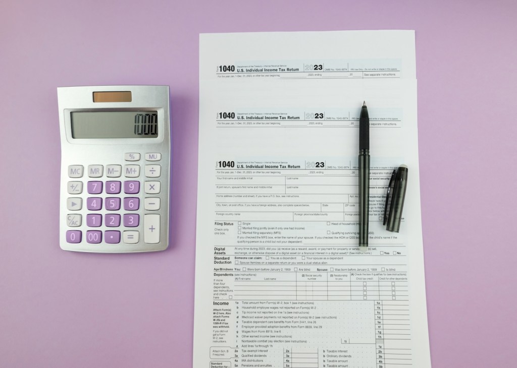 Ein Steuerformular mit Taschenrechner und Stift auf lila Hintergrund.