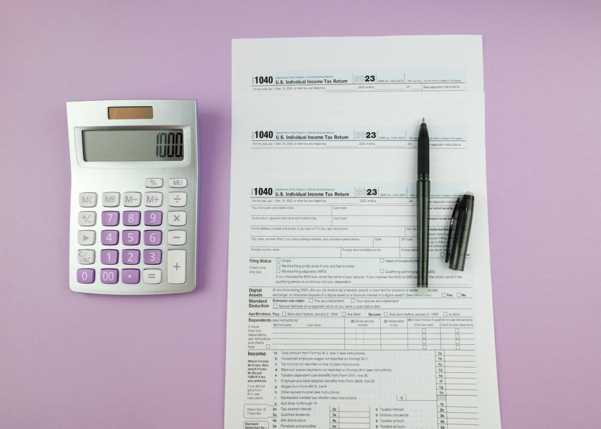 Ein Steuerformular mit Taschenrechner und Stift auf lila Hintergrund.