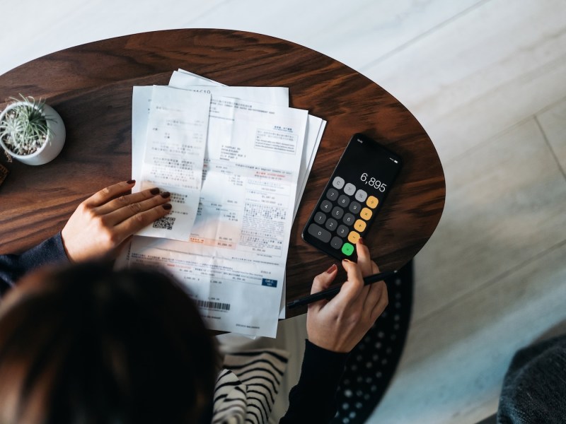 Draufsicht einer jungen Asiatin, die zu Hause ihre Finanzen verwaltet.