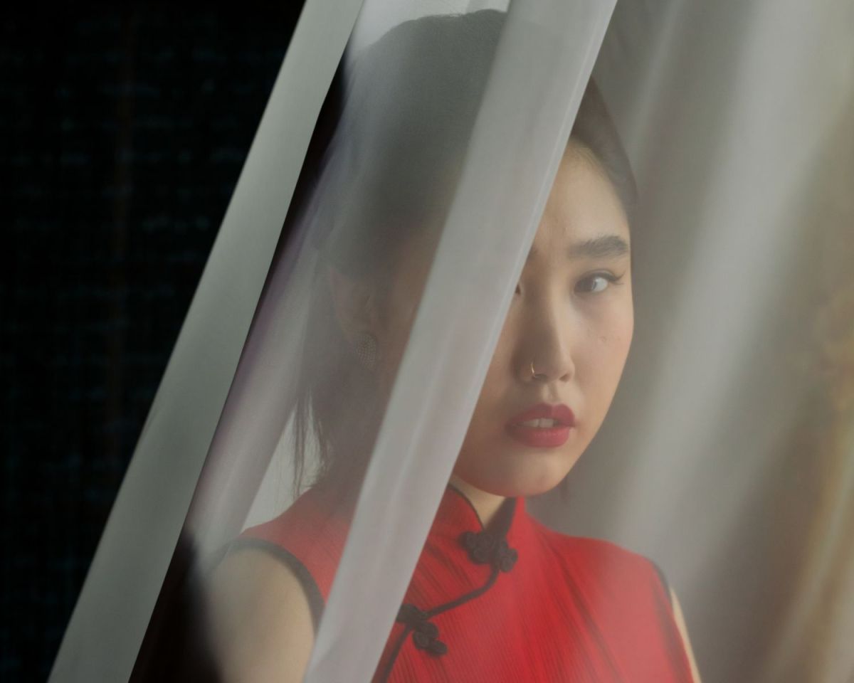 Frau hinter einer Gardine