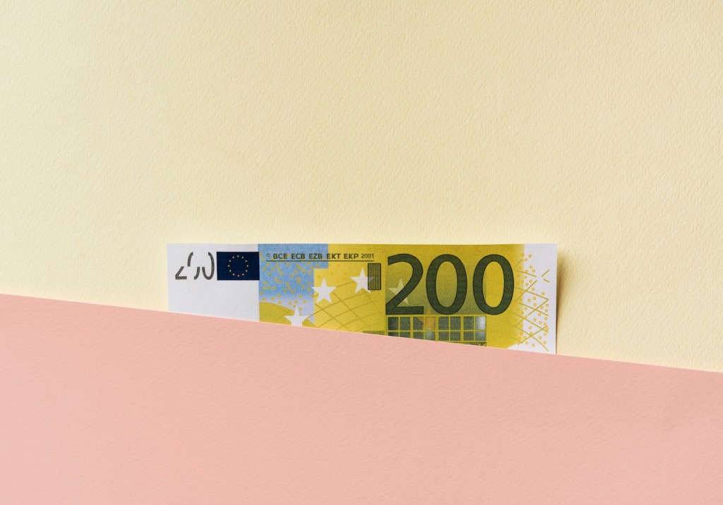 Zweihundert-Euro-Banknote zwischen pastellfarbenen Schichten.