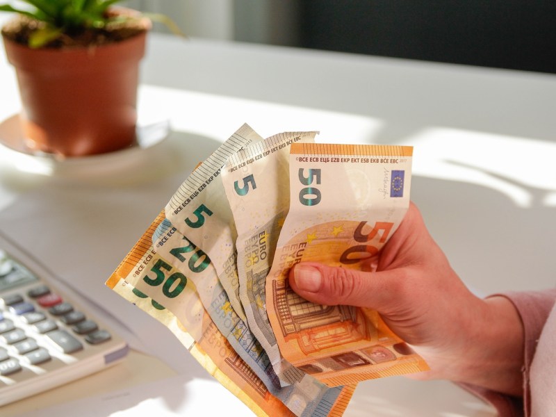 Eine Frau hält Geldscheine in der Hand.