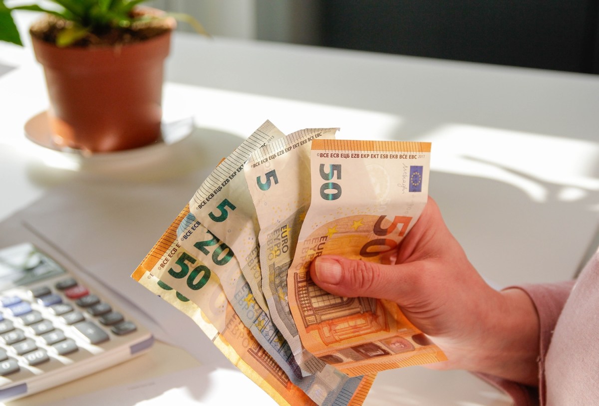 Eine Frau hält Geldscheine in der Hand.