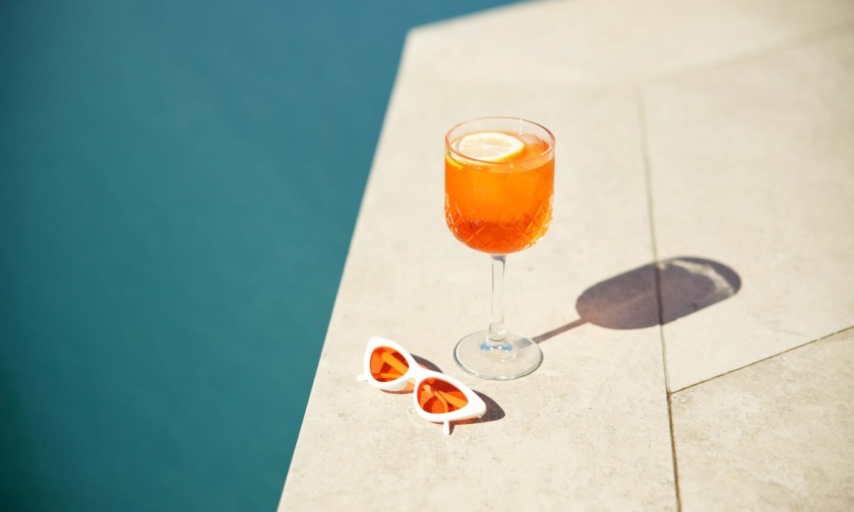 Ein Cocktail und Sonnenbrille am Pool.