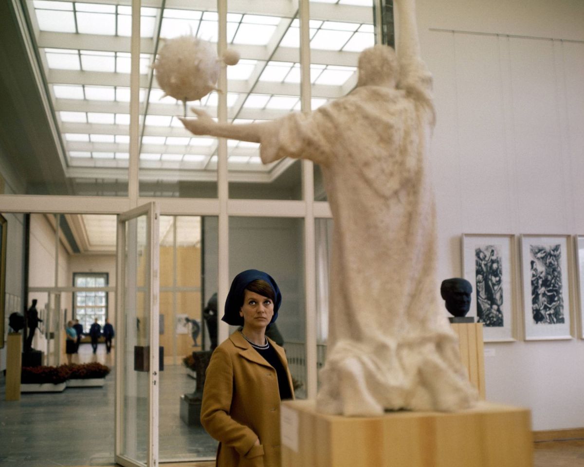 Frau in der DDR schaut sich Kunstwerke an.