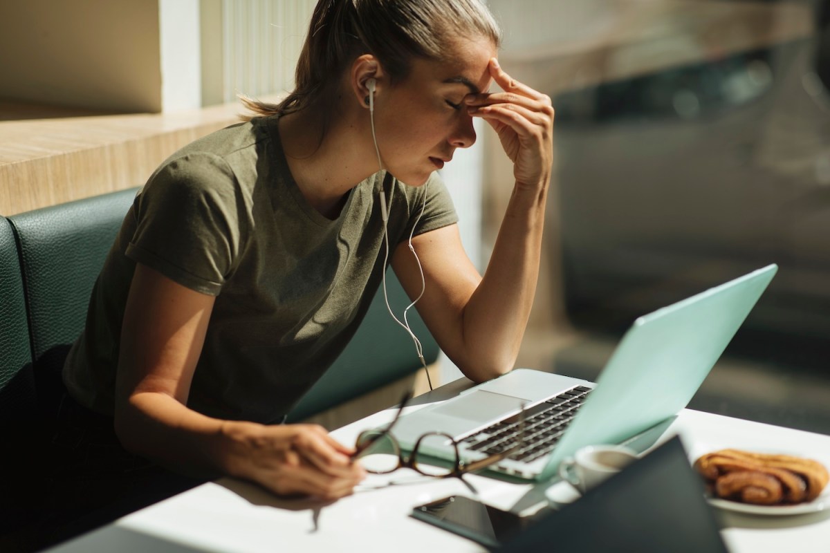 Aufnahme einer jungen Frau, die während ihres Arbeitstages unter Müdigkeit leidet.