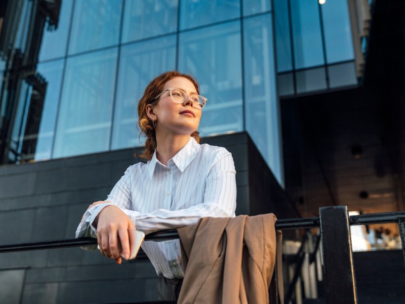 Nachdenkliche Geschäftsfrau stützte sich auf Geländer.