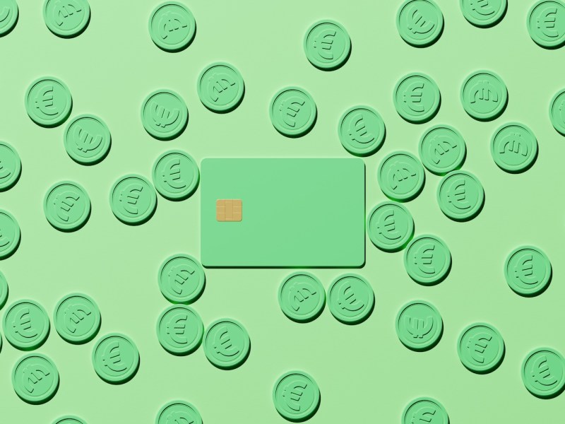 Digital generiertes Bild einer pastellgrünen Kreditkarte mit Chip, umgeben von verstreuten grünen Euromünzen auf grünem Hintergrund.