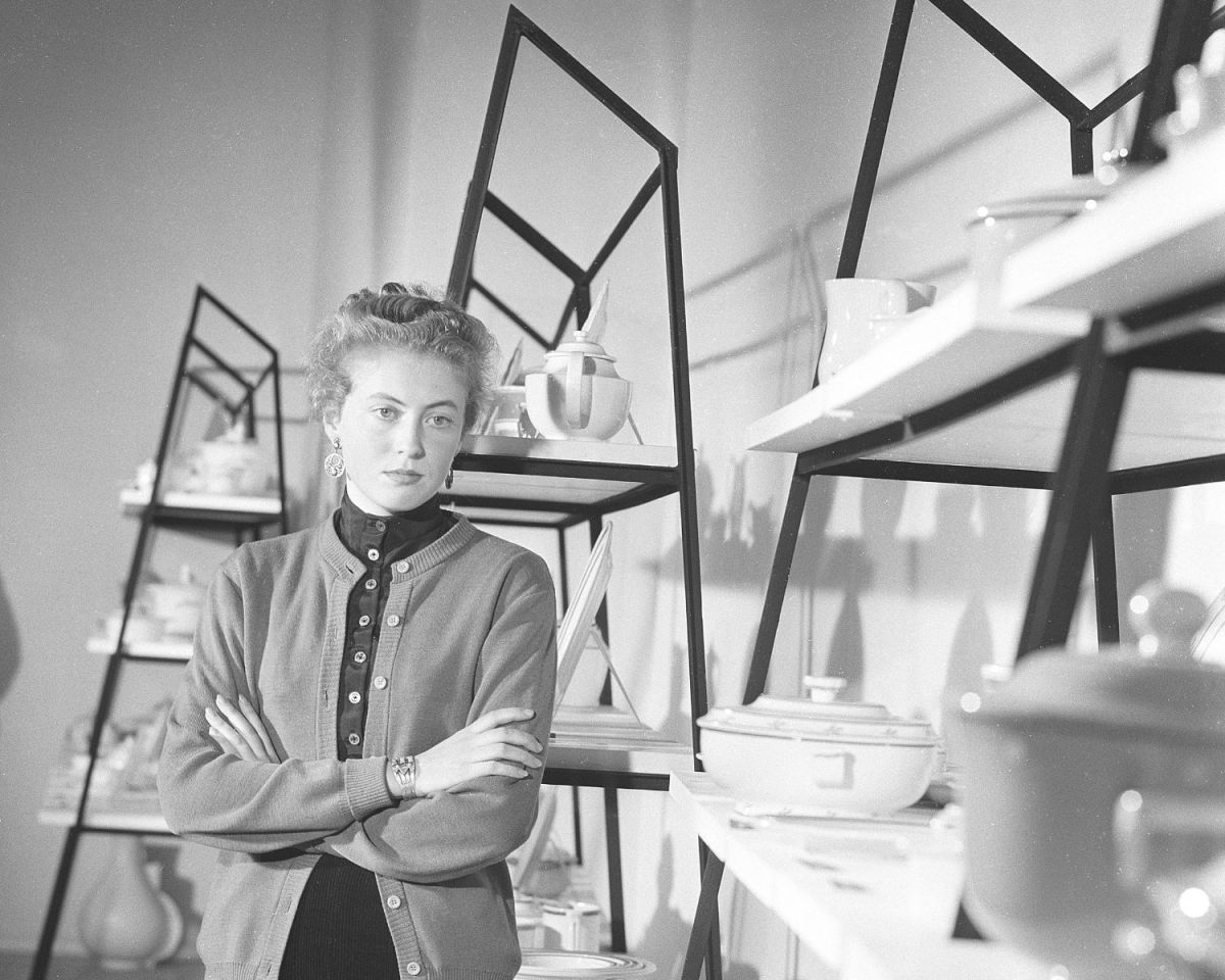 Frau steht vor einem Mid-Century Modern Regal