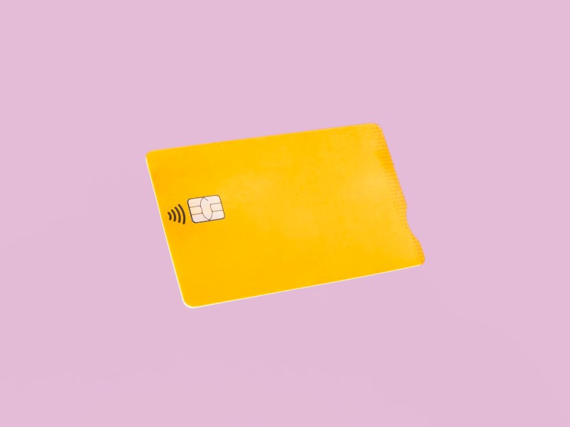 Vorderansicht der gelben Kreditkarte auf rosa Hintergrund.