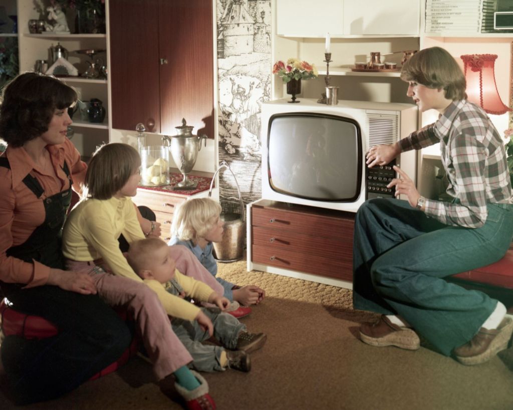 Familie sitzt vor einem DDR-Fernseher.