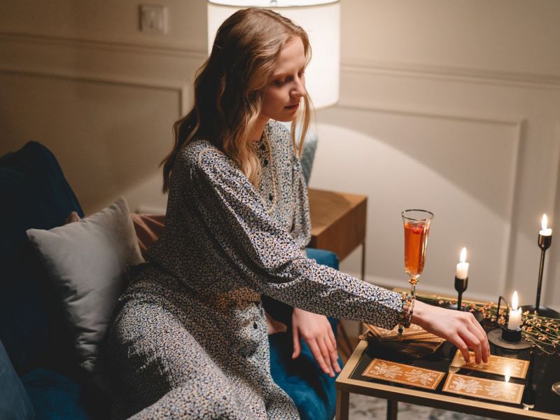 Frau sitzt auf dem Sofa mit Kerzen