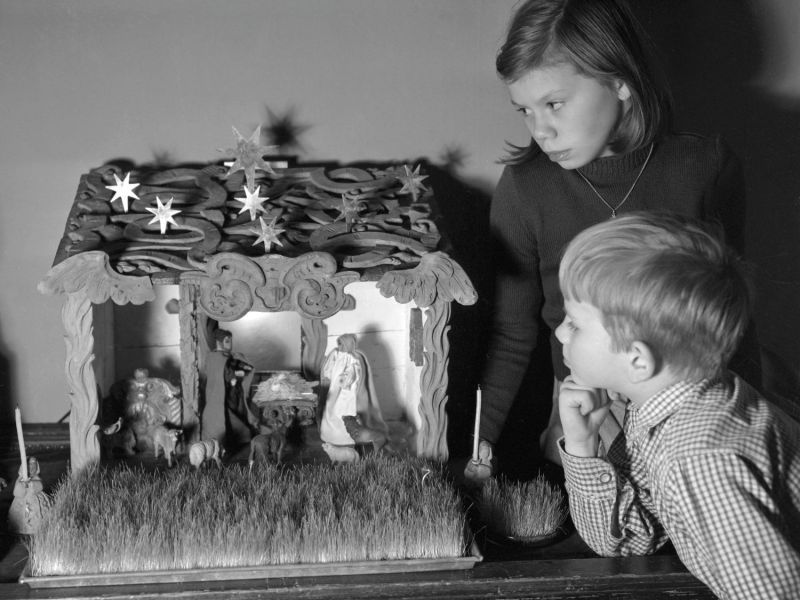 Kinder schauen Krippenfiguren an