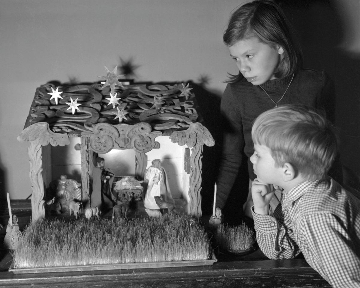 Kinder schauen Krippenfiguren an