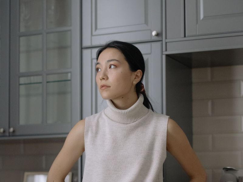 Frau steht vor einem Küchenschrank.