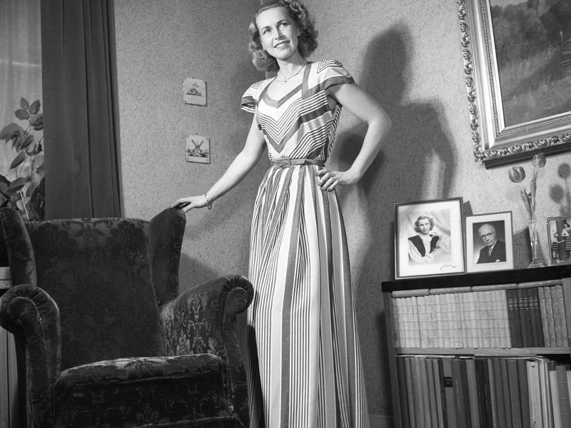 Frau steht neben einem Ohrensessel