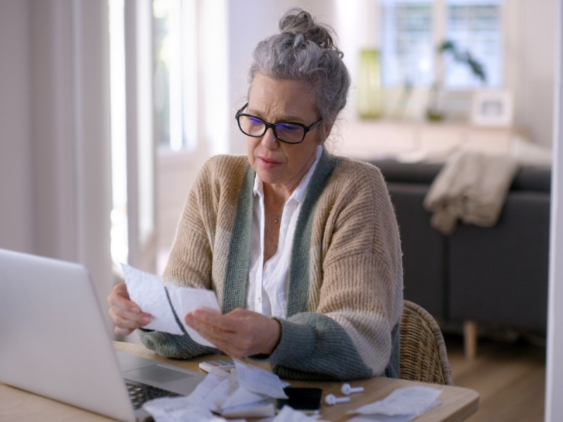 Laptop, Finanzen und Budget mit einer älteren Frau, die ihr Geld von zu Hause aus verwaltet.