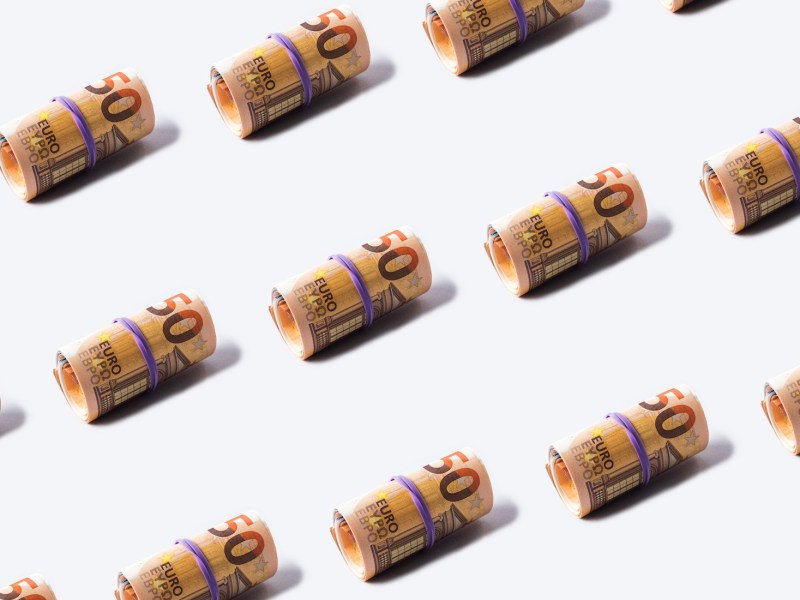 50-Euro-Banknoten rollen Muster auf grauem Hintergrund.