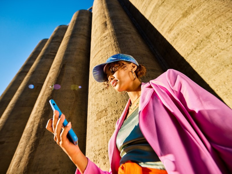 Junge Frau schaut auf ihr Handy.