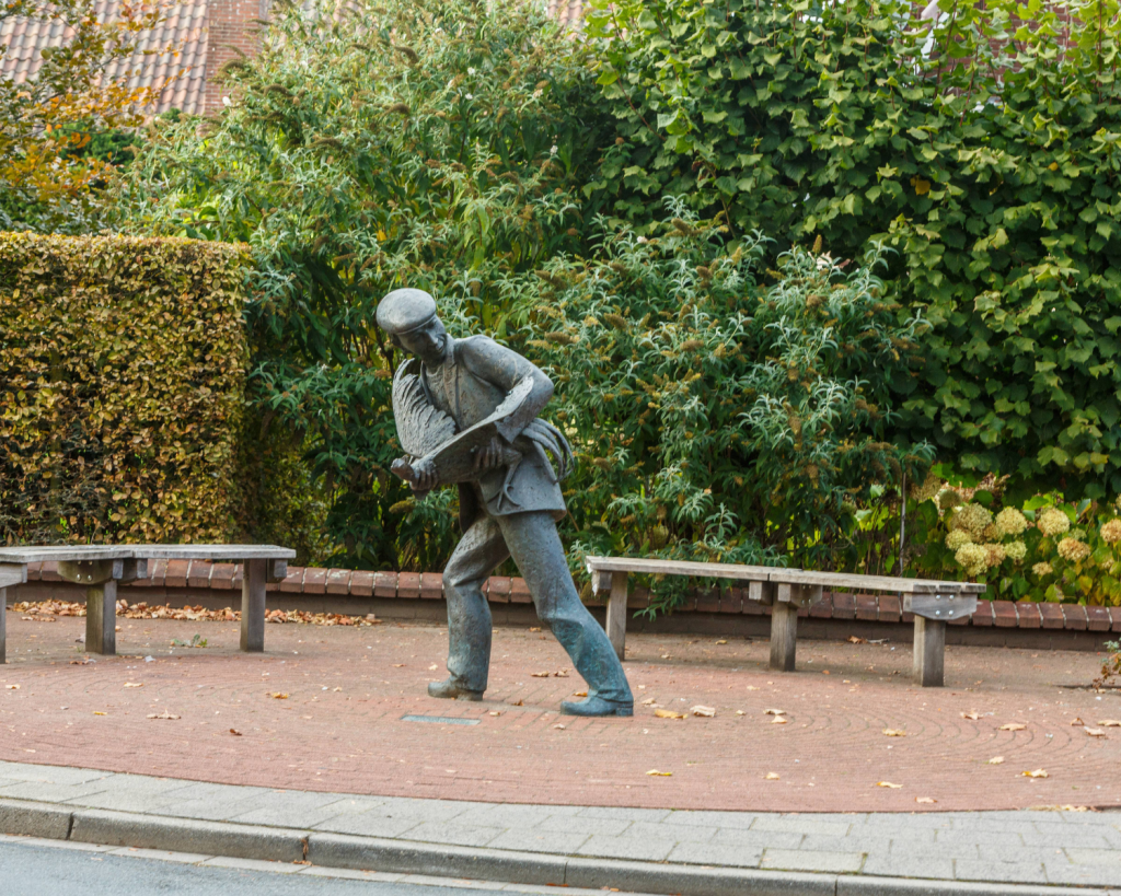 Bronzefiguren von Schmuggler*innen und Z&ouml;llner*innen erinnern auf dem Dorfplatz an fr&uuml;here Zeiten.