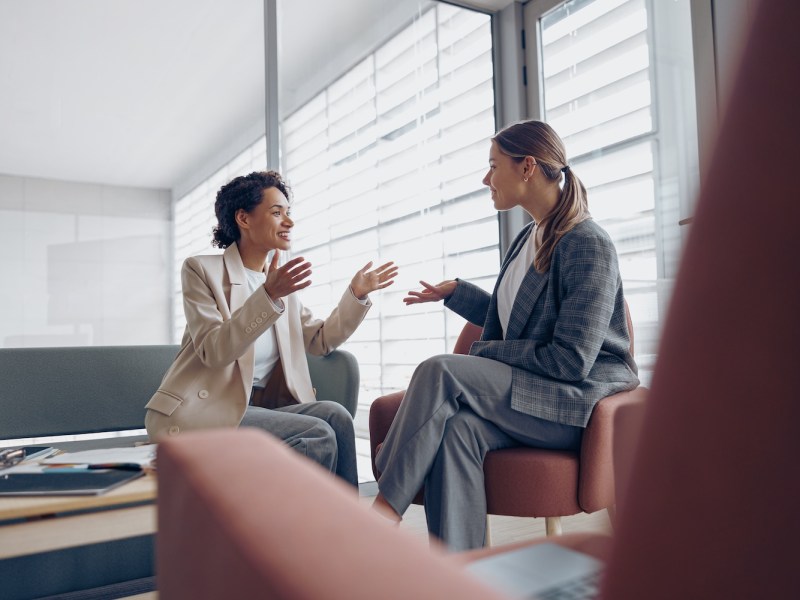 Zwei Frauen unterhalten sich im Büro.